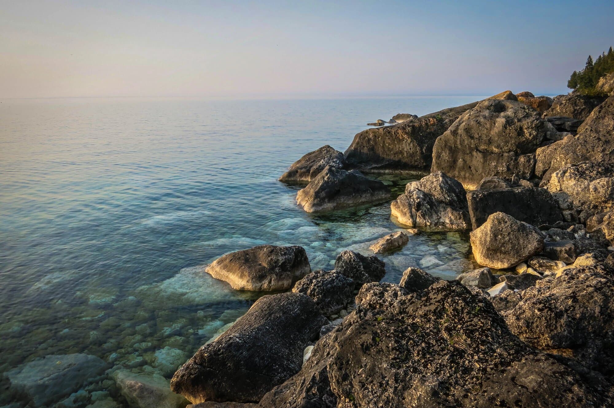Boulders on the shoreline at Lion's Head with calm water beyond